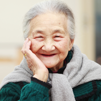 Older Asian woman smiling at the camera